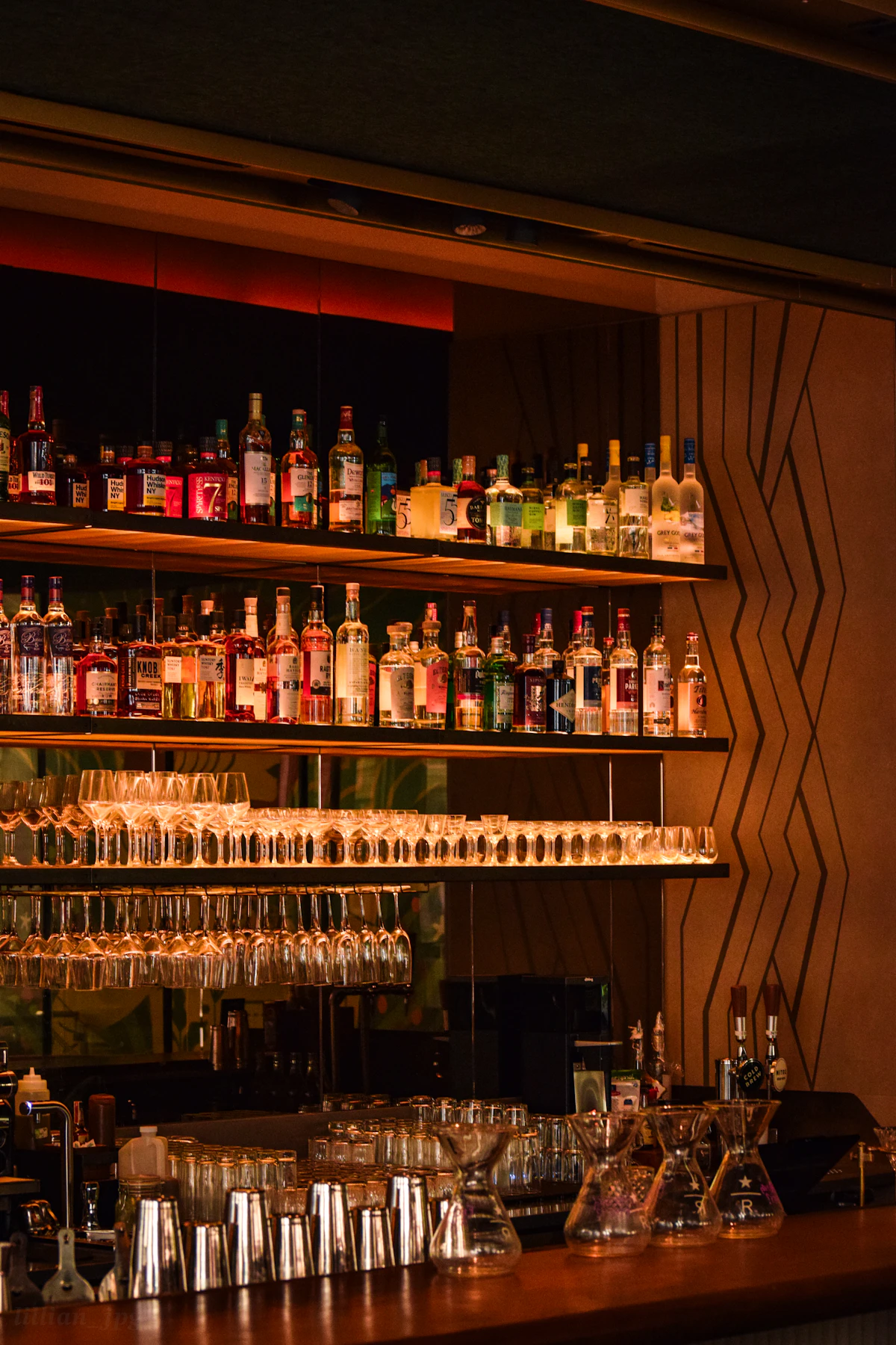 Bar bem iluminado com garrafas e copos