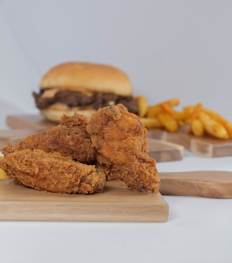 a fried chicken sandwich and french fries on a cutting board