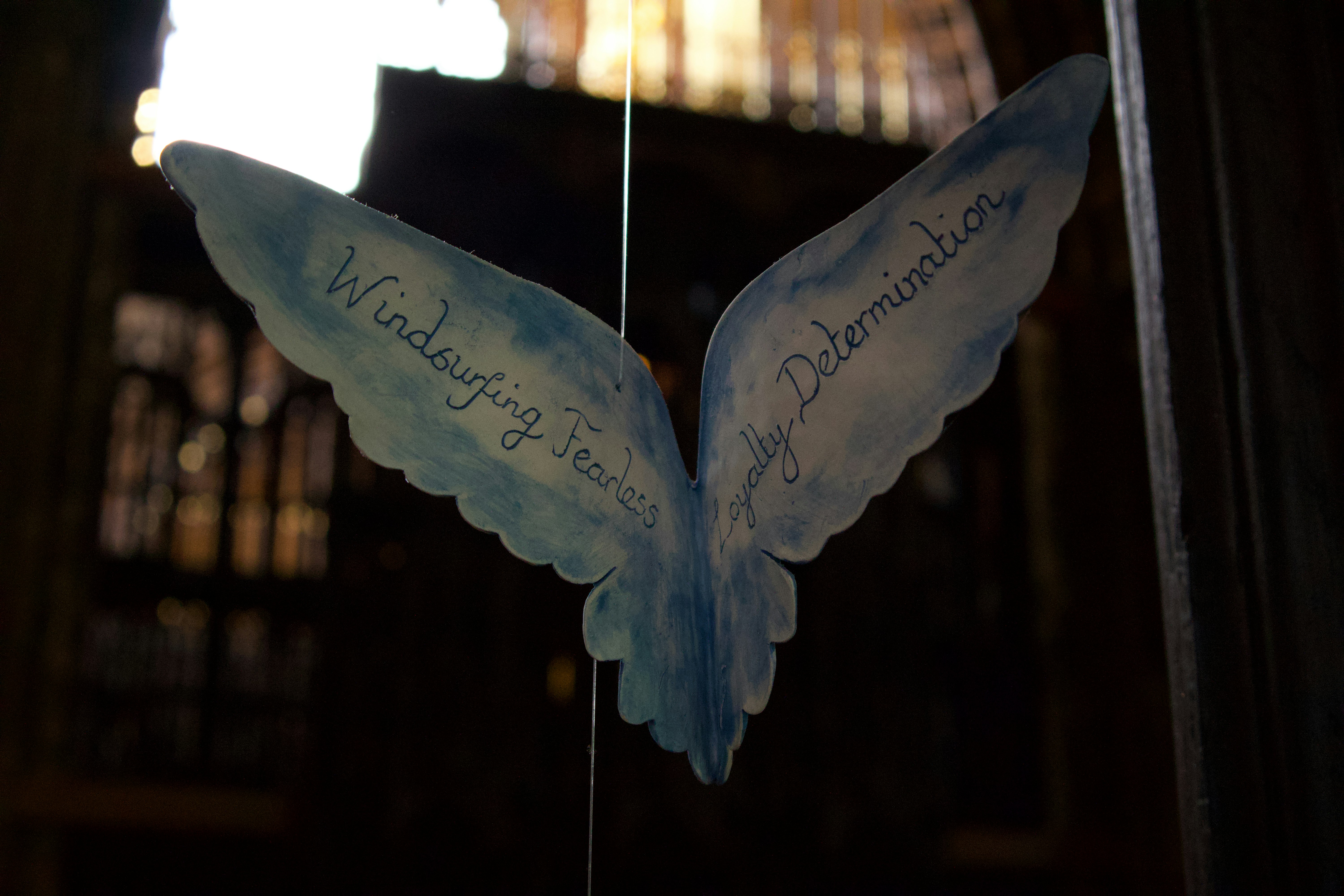 a paper angel with writing on it hanging from a string