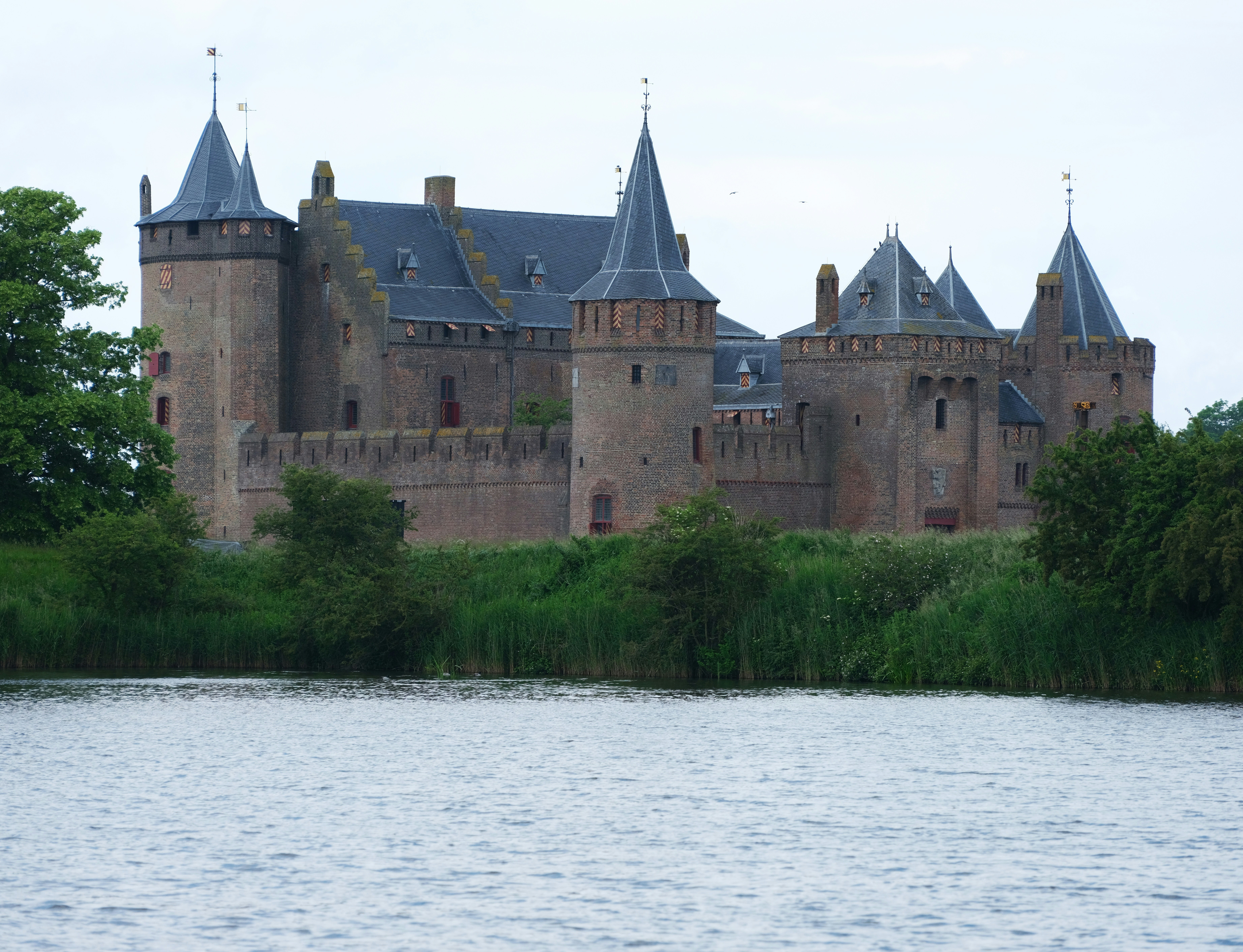 a large castle sitting on top of a lush green hillside