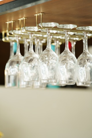 a row of wine glasses sitting on top of a shelf