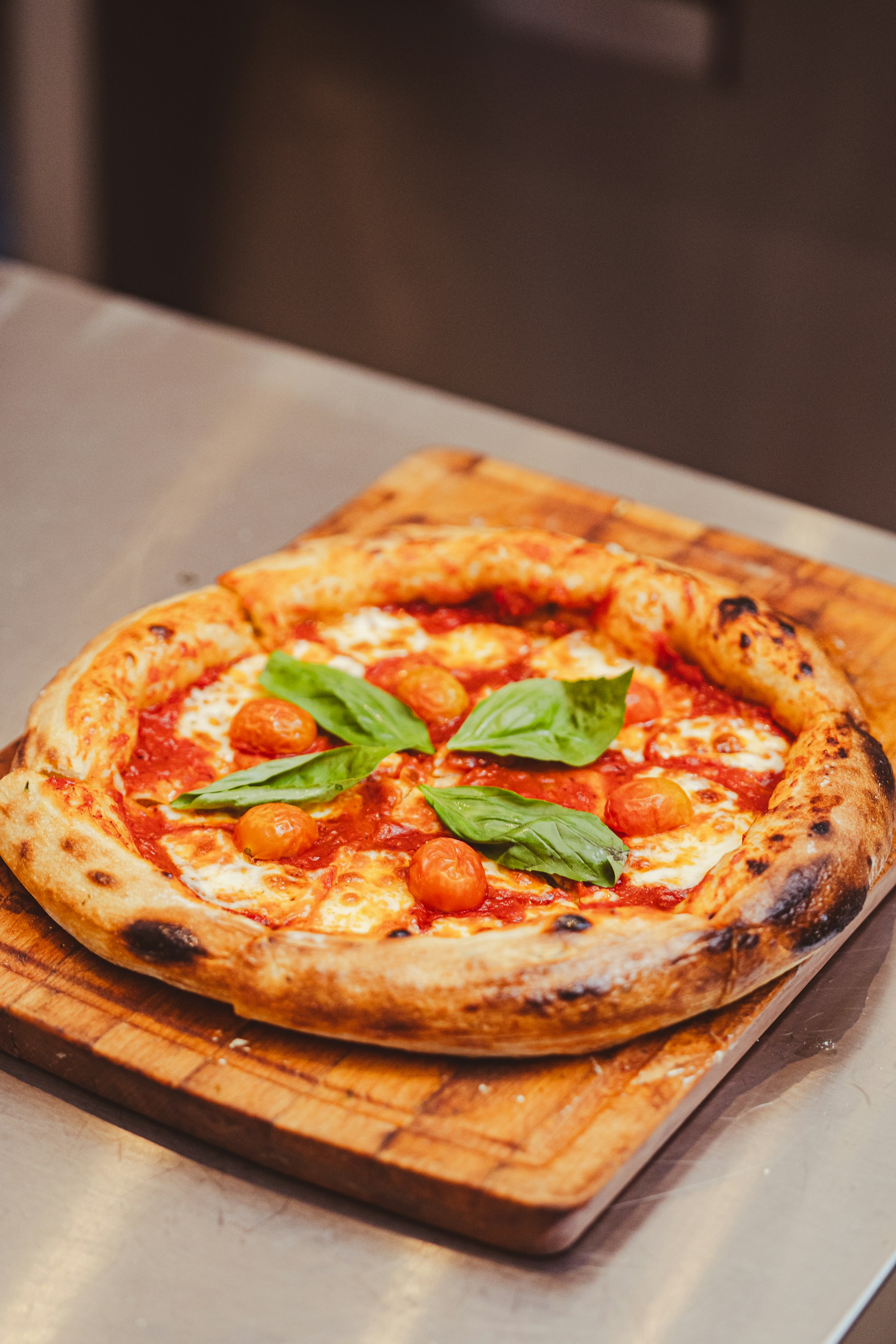 a pizza sitting on top of a wooden cutting board
