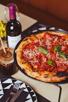 a pizza sitting on top of a pan next to a bottle of wine