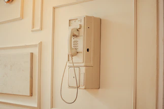 an old phone is hanging on the wall