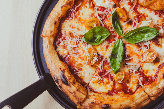 a pizza sitting on top of a pan covered in cheese