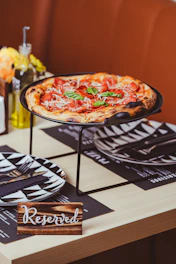 a pizza sitting on top of a metal tray on a table