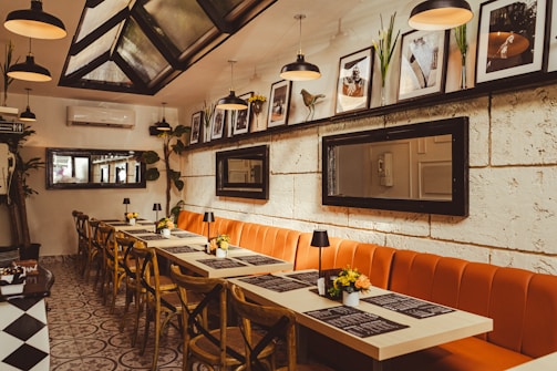 a restaurant with a long table and orange benches