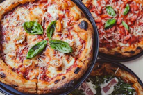 a couple of pizzas sitting on top of a table