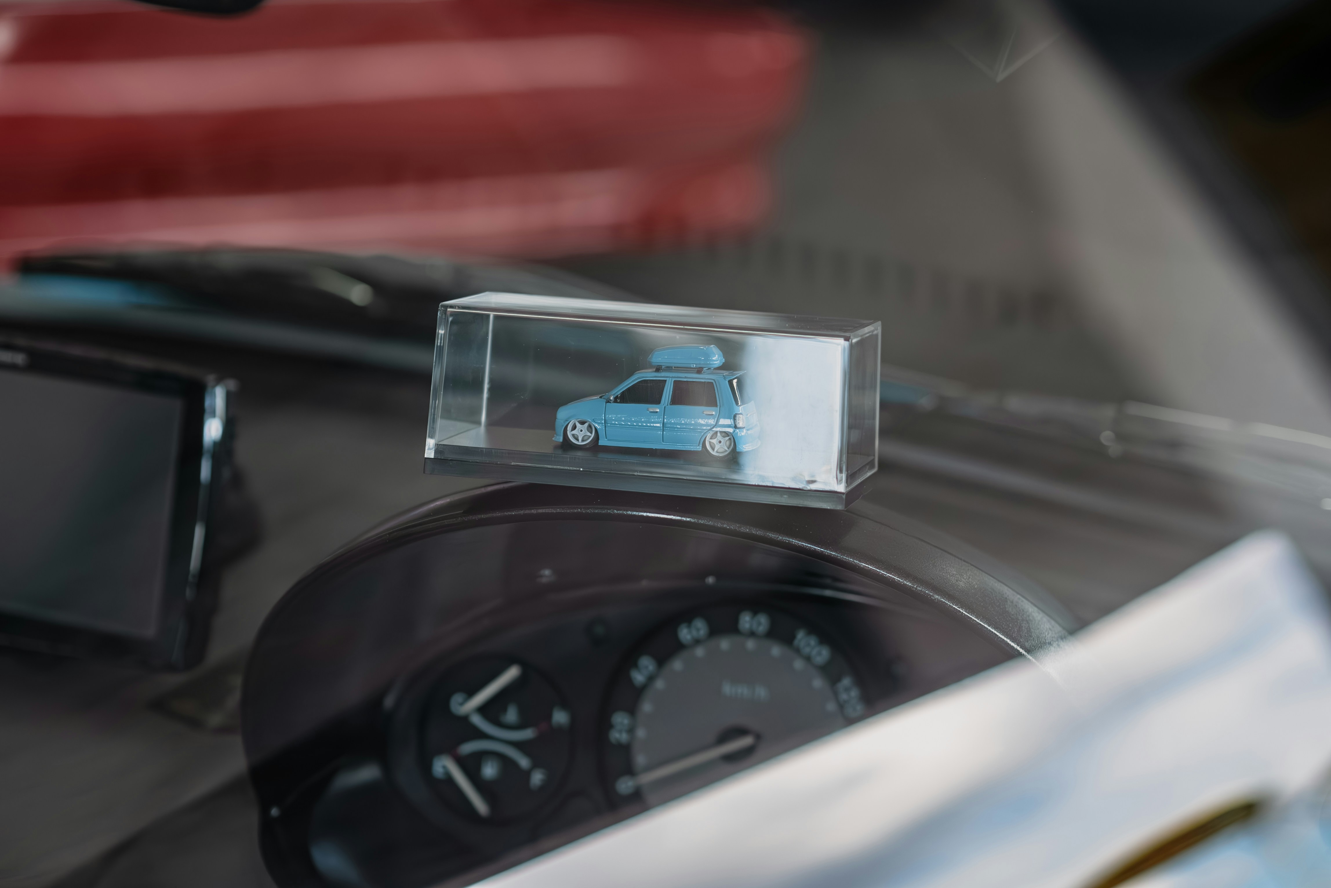 a car dashboard with a small blue car in the middle of it