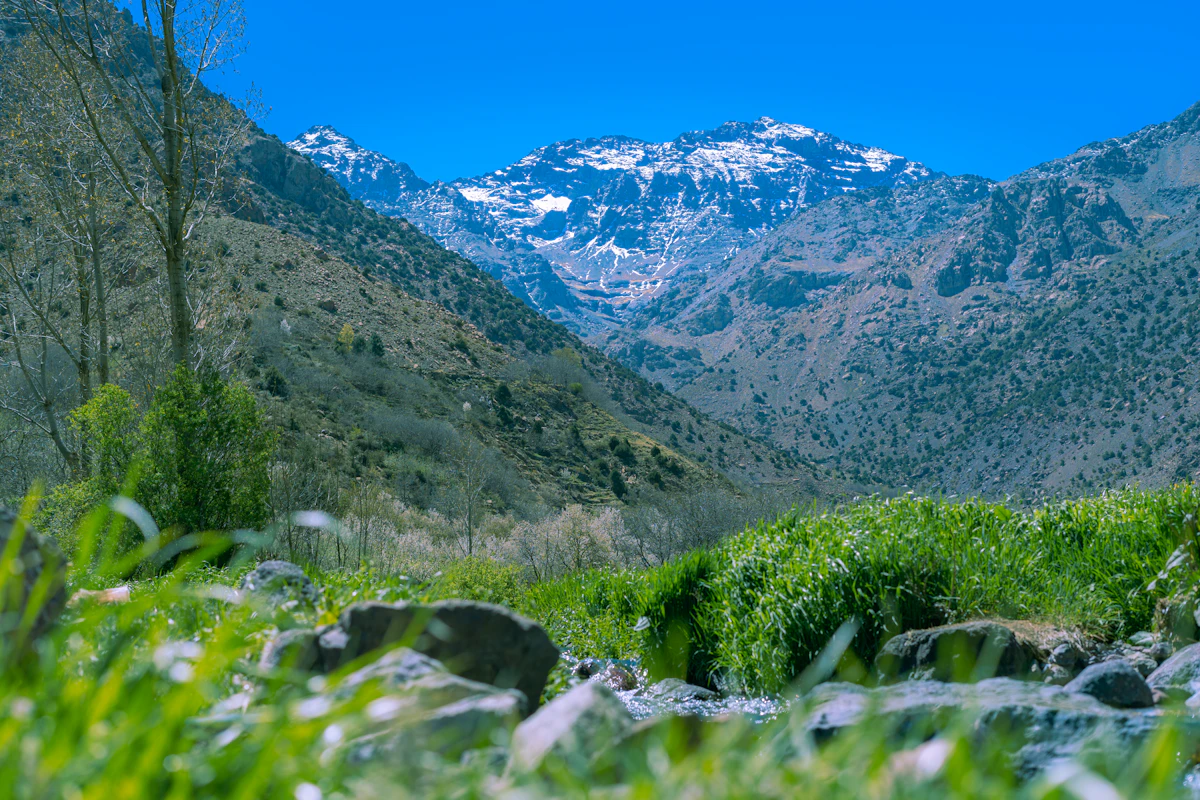 A mountain range with a stream running through the Imlil Valley, Morocco