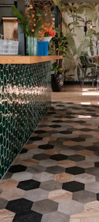 a tiled floor in a restaurant with potted plants