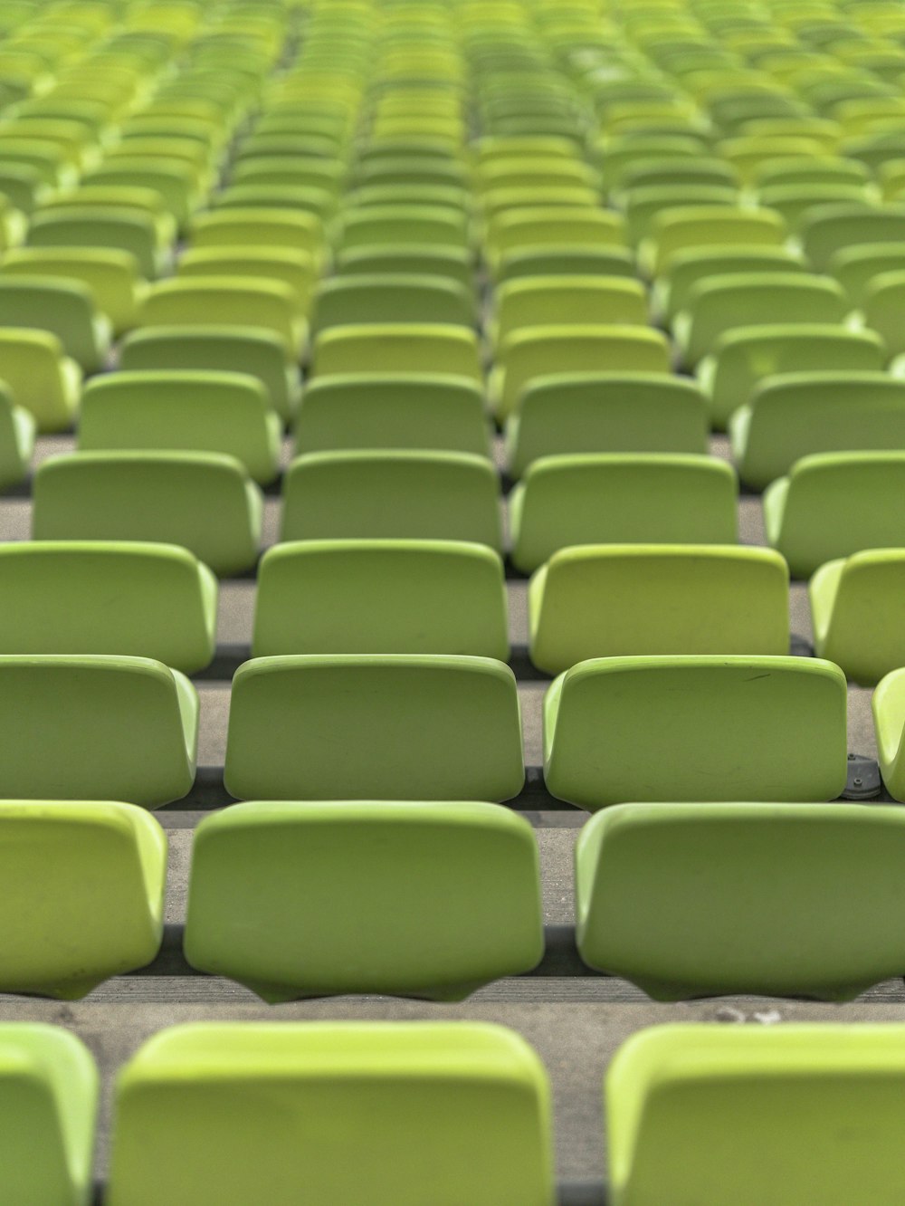 Filas de asientos de plástico verde en un estadio