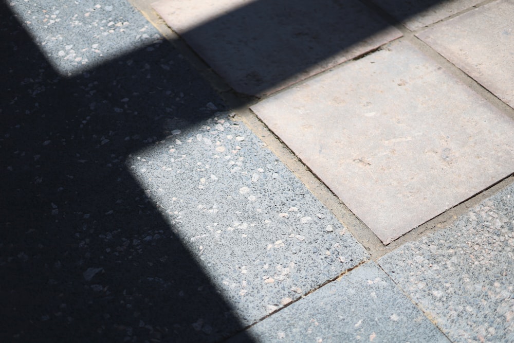 the shadow of a person walking on a sidewalk
