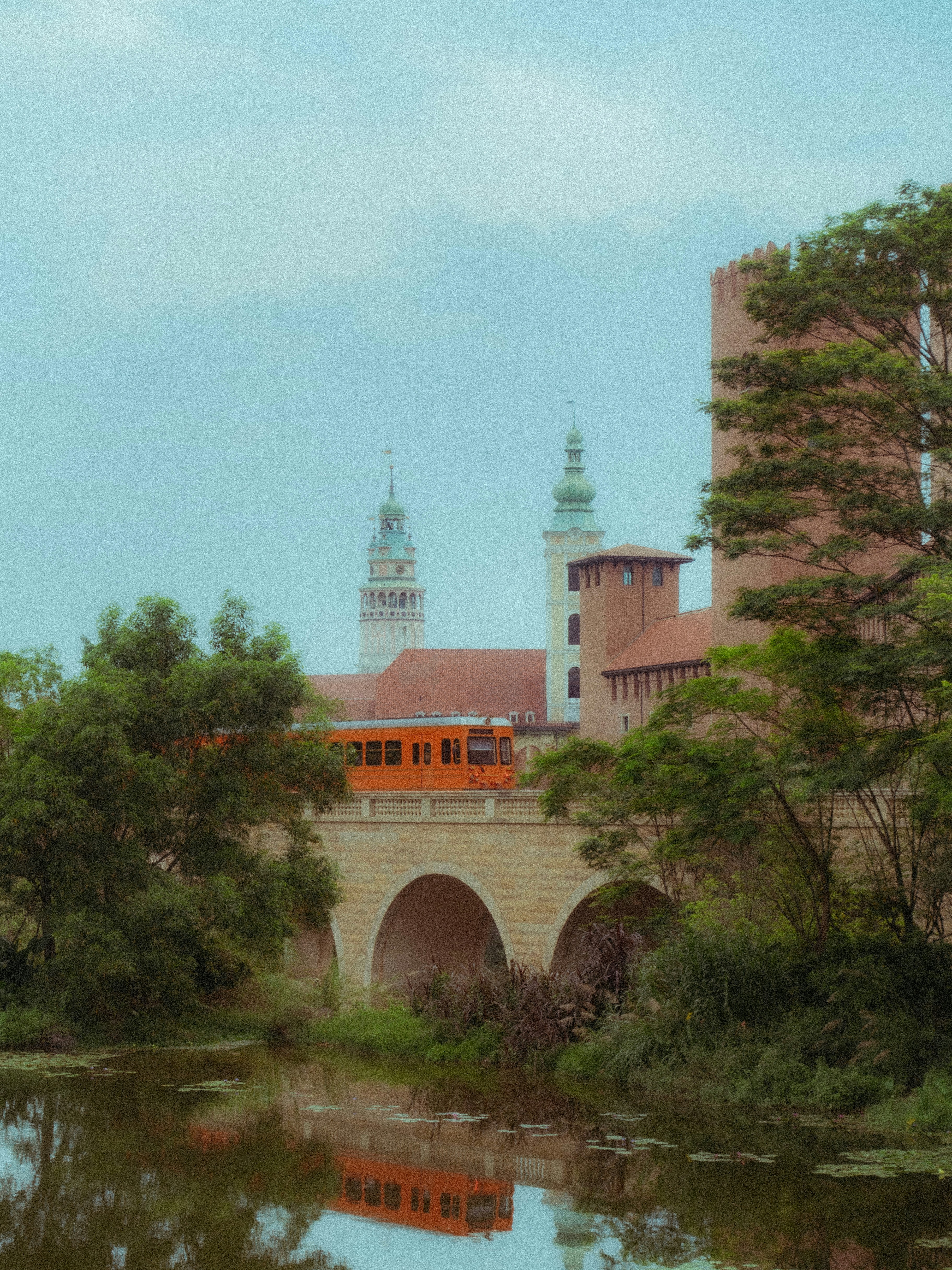 a bridge over a body of water with a clock tower in the background