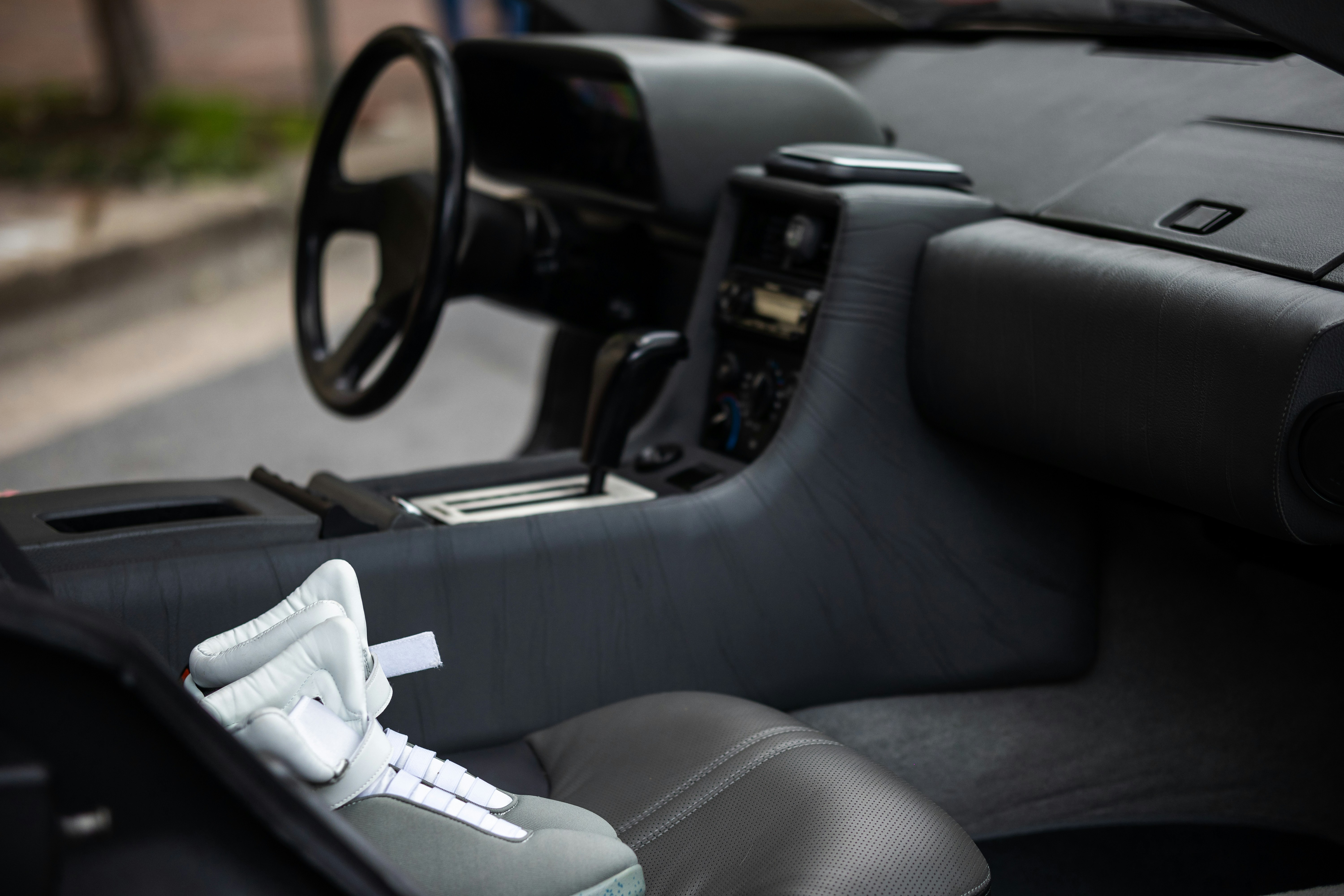 a pair of sneakers sitting in the driver's seat of a car