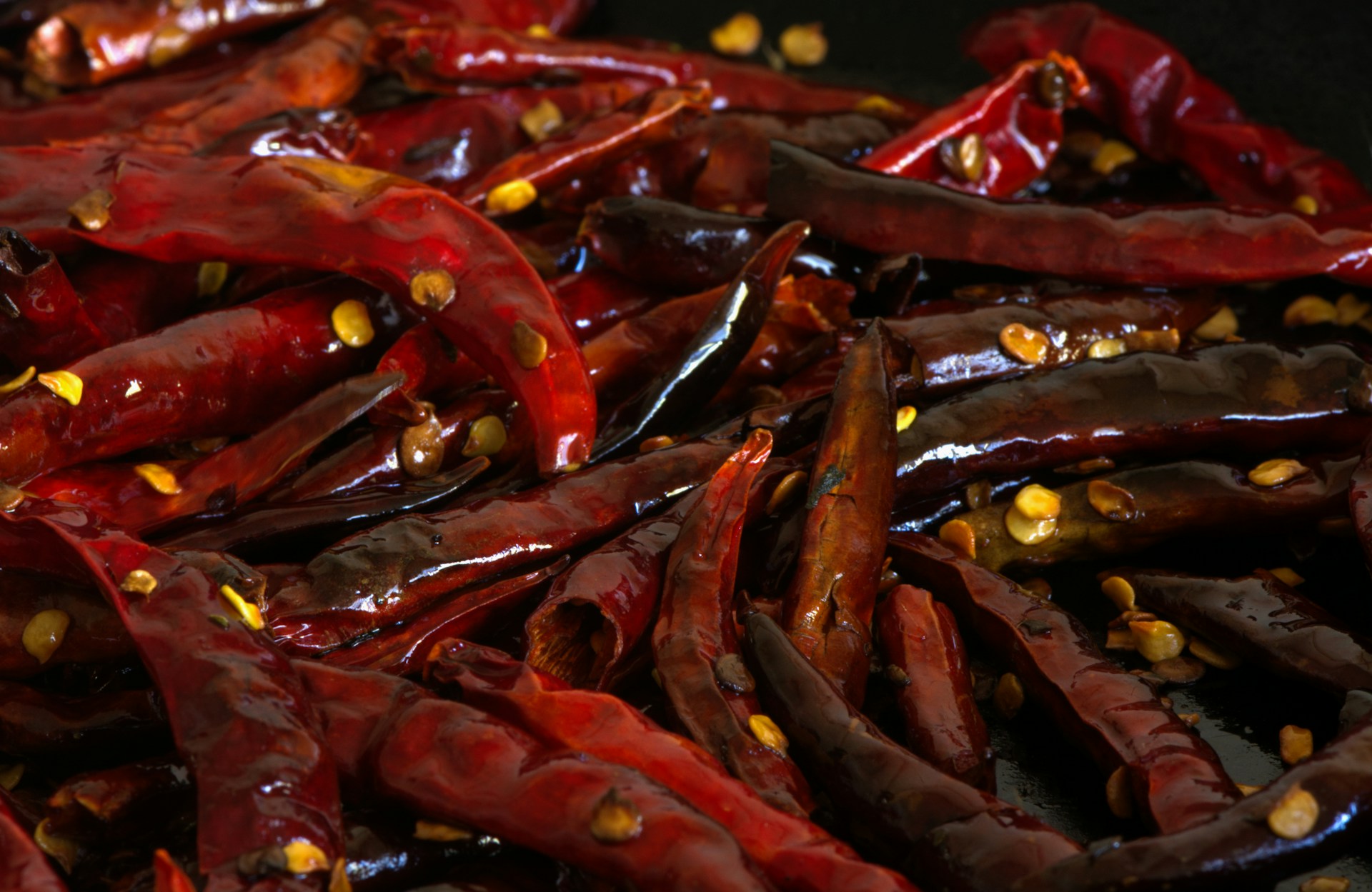 a pile of red peppers with yellow seeds