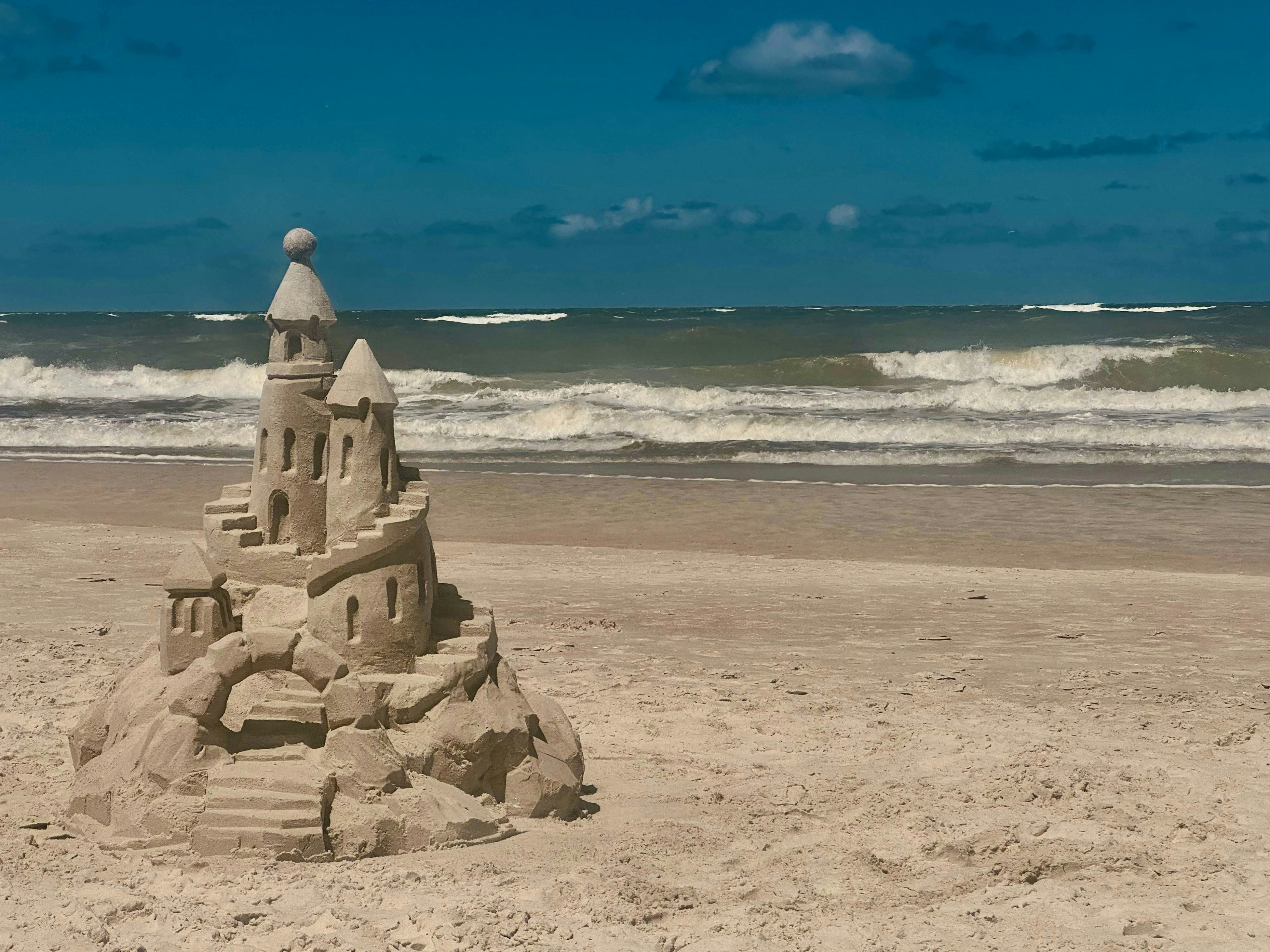 un château de sable sur une plage près de l’océan