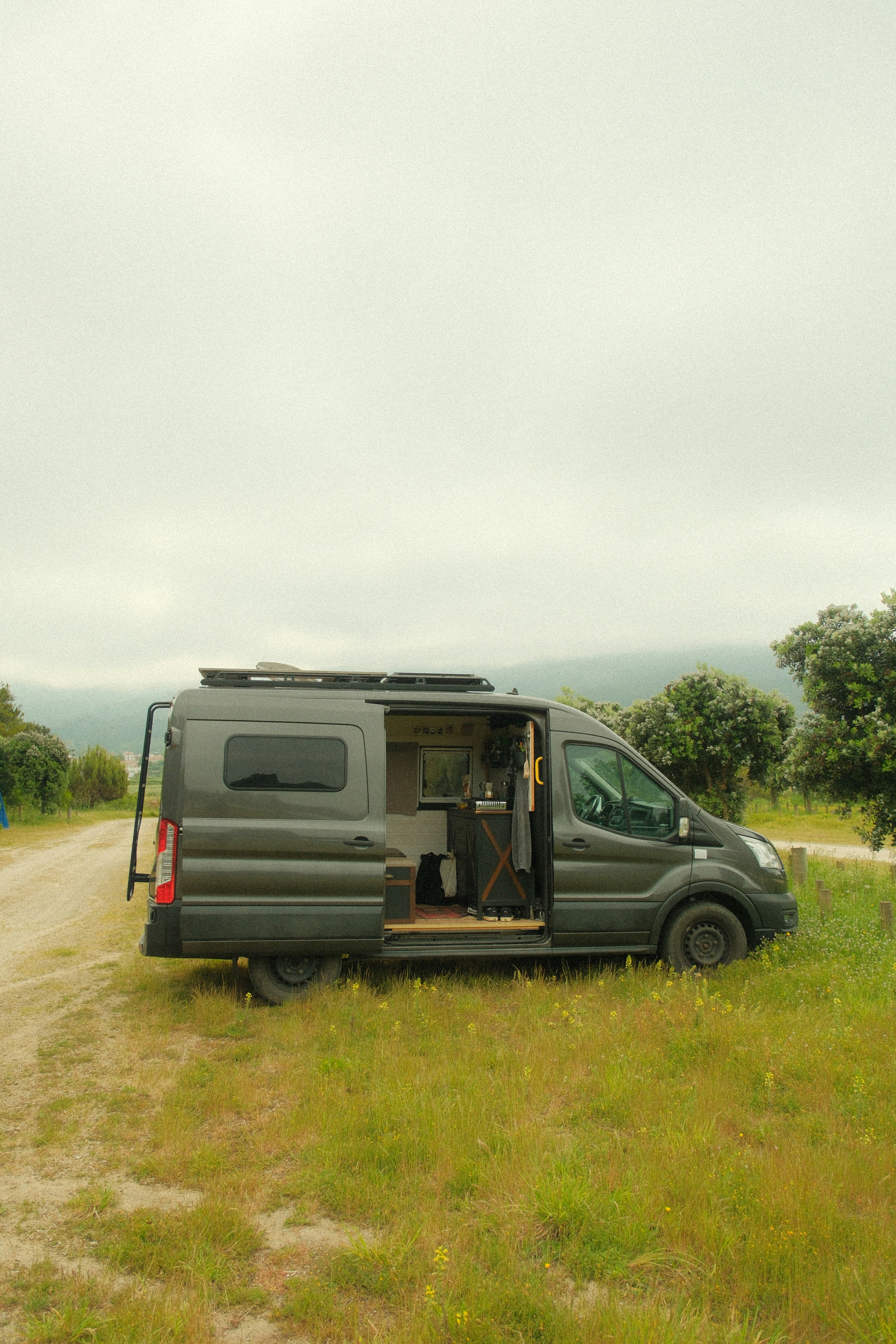 a van is parked on a dirt road