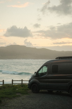a van parked on the side of a road near the ocean