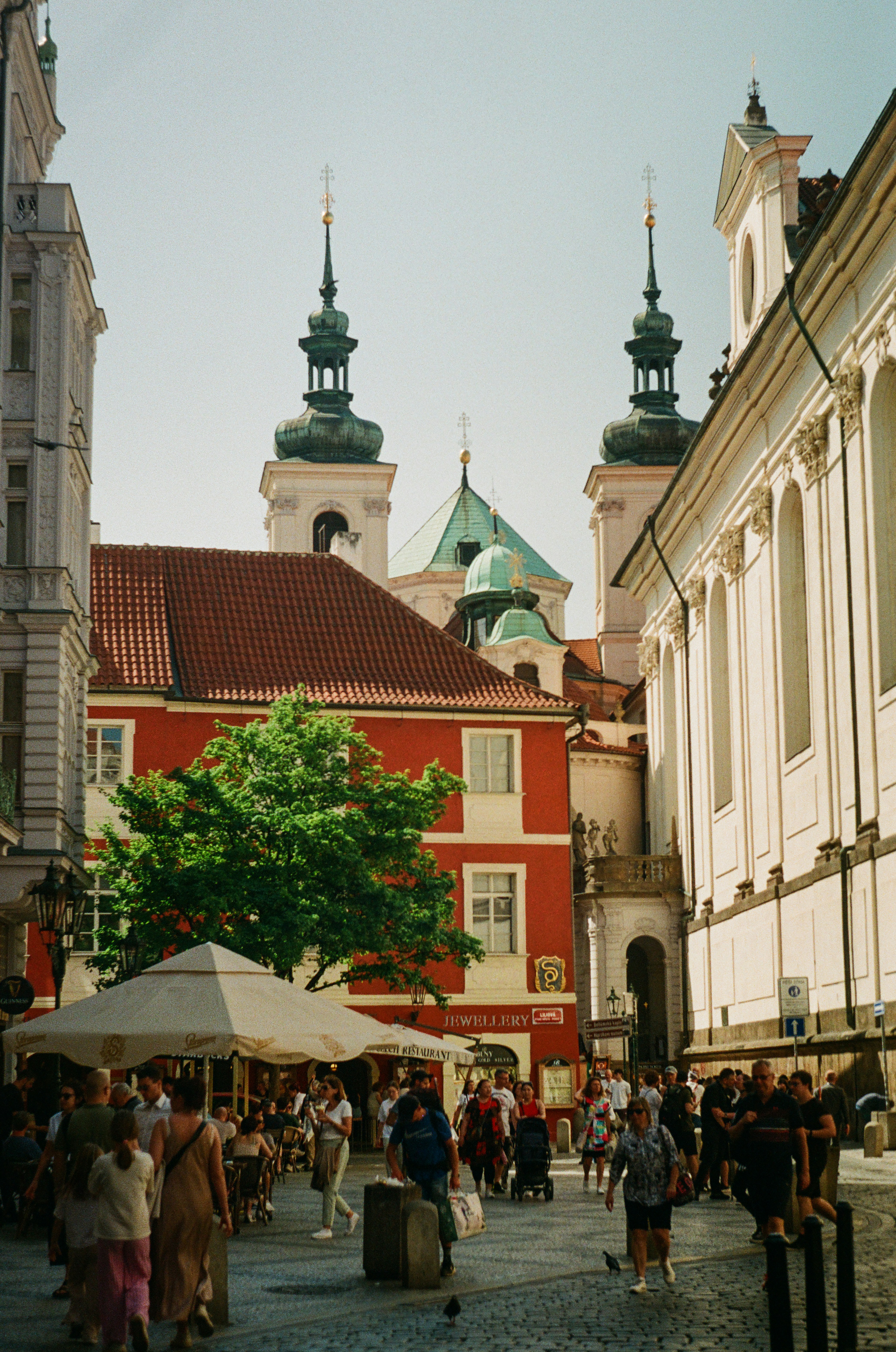 a group of people walking down a street next to tall buildings