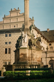 a statue in front of a building with a clock tower