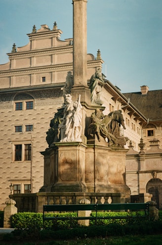 a statue in front of a building with a clock tower