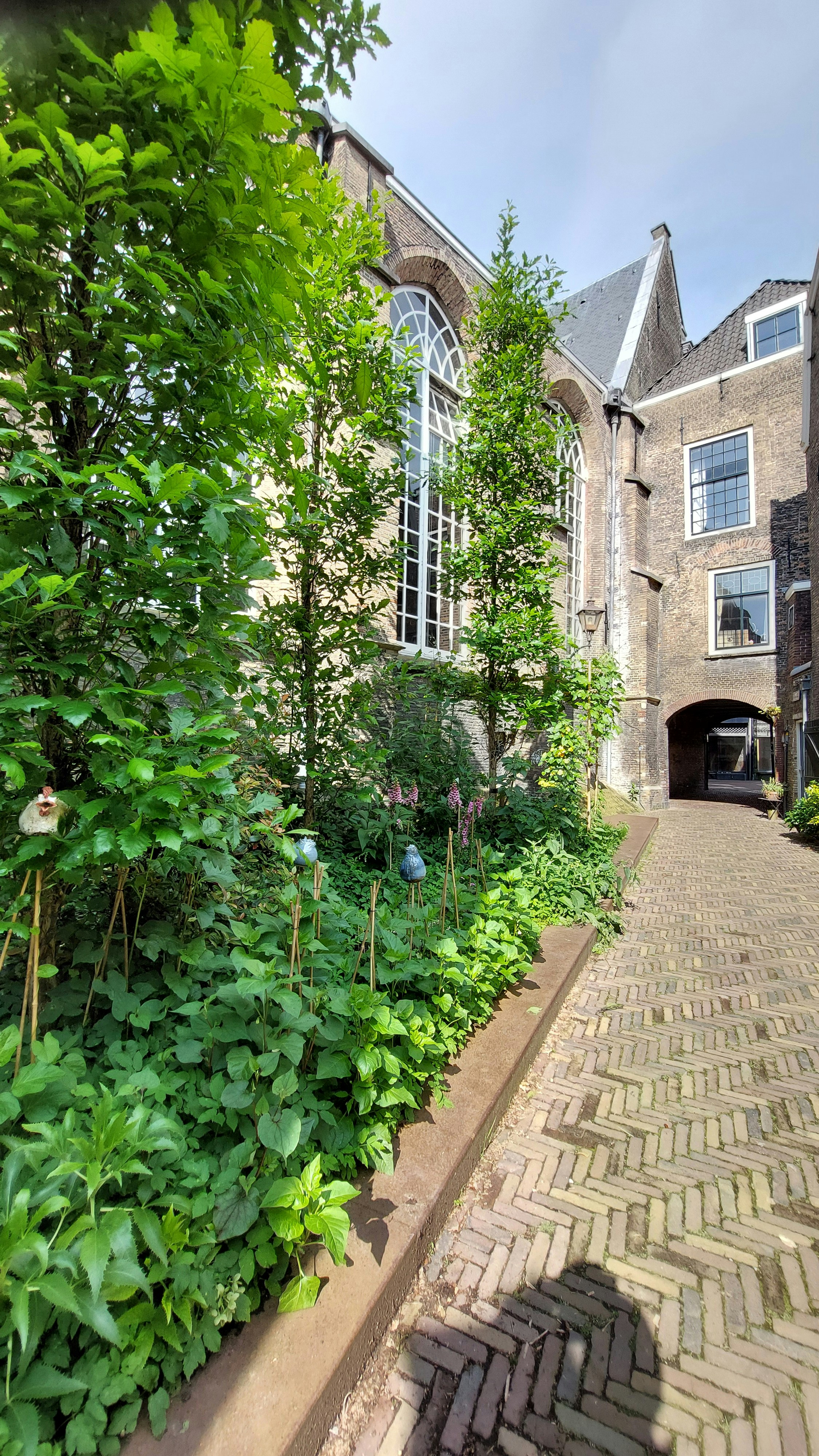 a brick walkway leads to a large brick house
