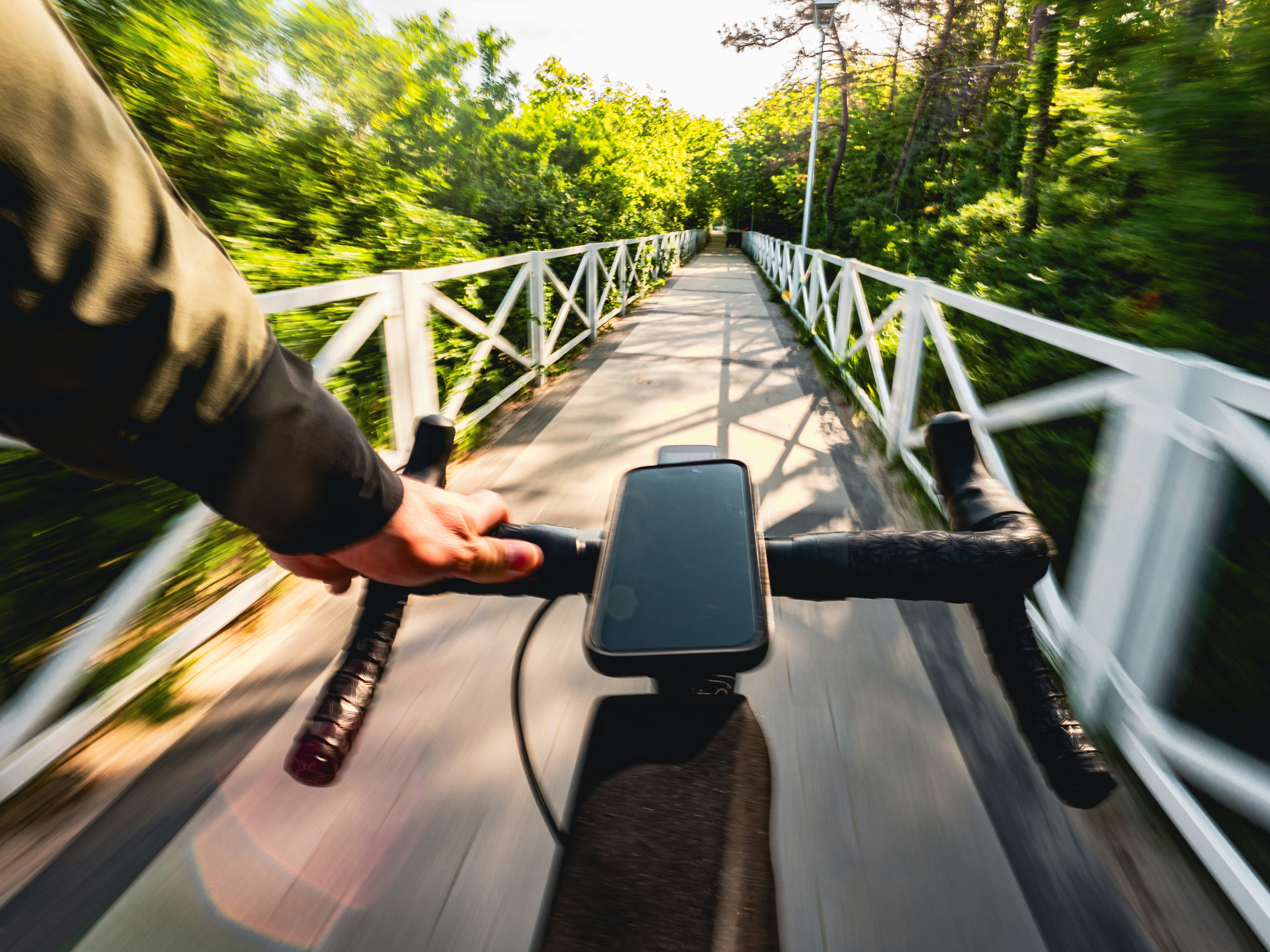 a person riding a bike with a cell phone in their hand