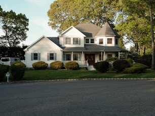 a large white house sitting on the side of a road