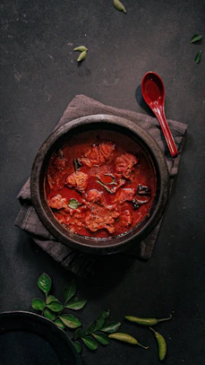 a bowl of food on a napkin next to a spoon