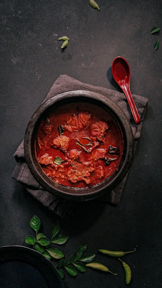 a bowl of food on a napkin next to a spoon