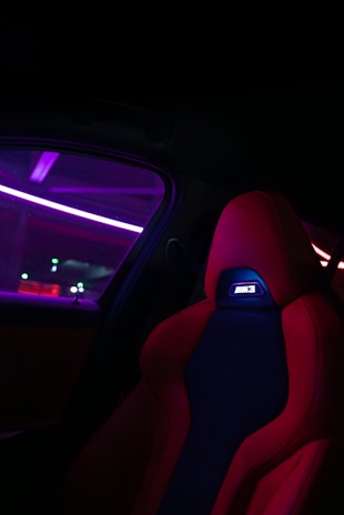 the interior of a car with red and blue leather seats