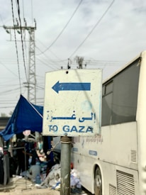 a sign pointing to the right in front of a bus
