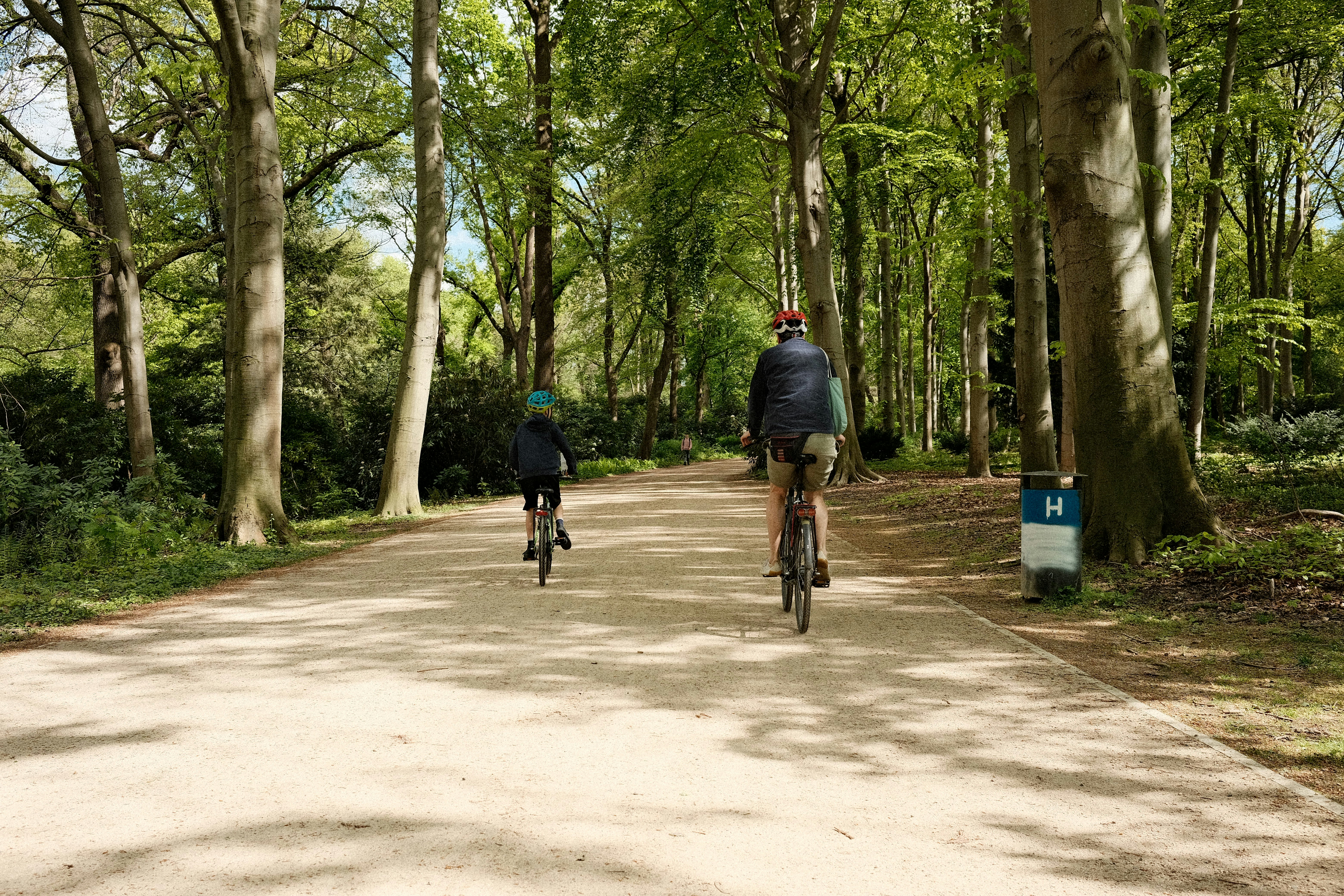 a couple of people riding bikes down a dirt road
