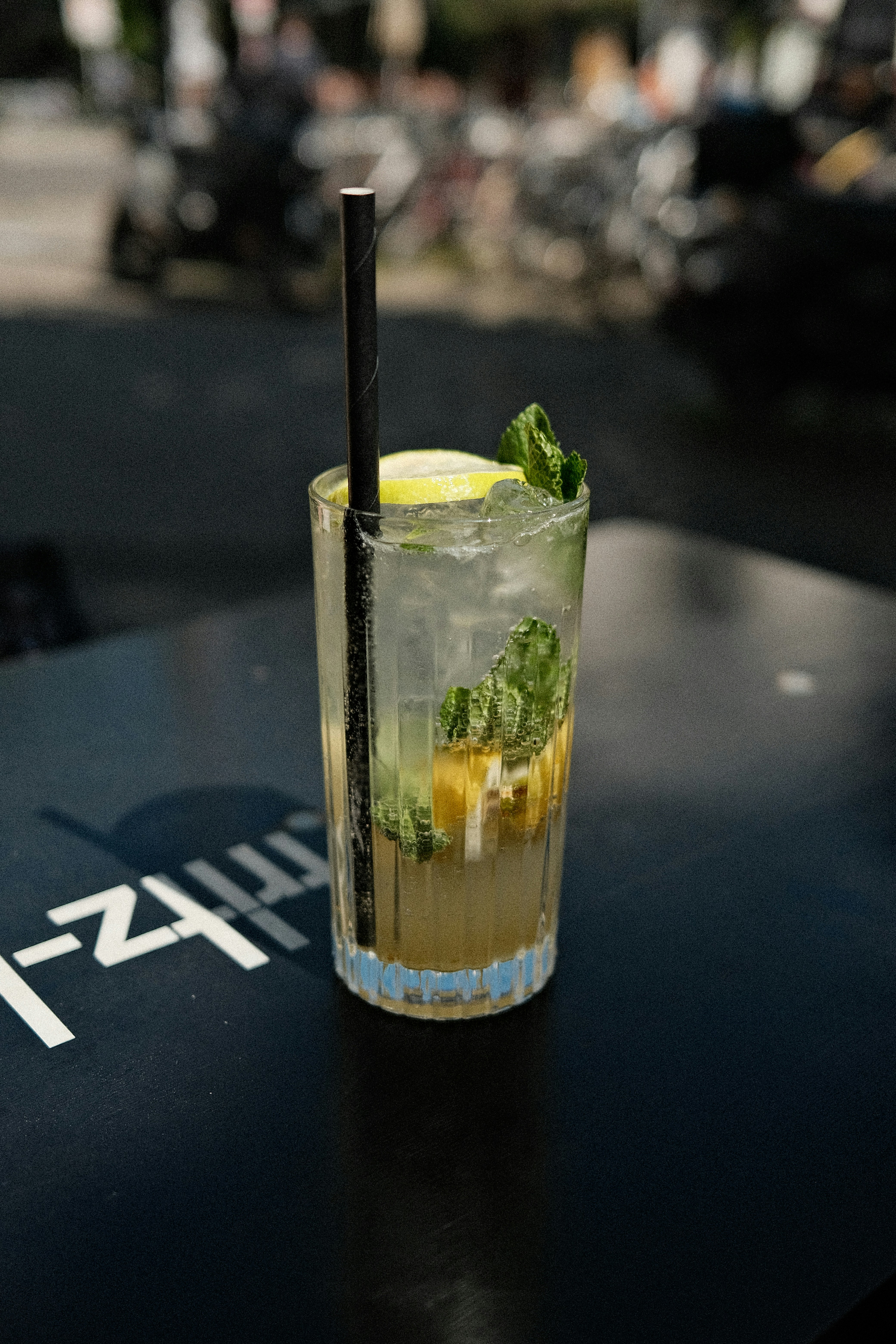 Mojito cocktail with fresh lime and mint leaves in a tall glass at a beach bar
