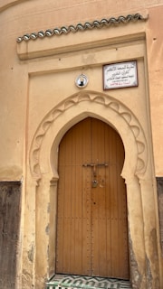 a large wooden door with a sign above it