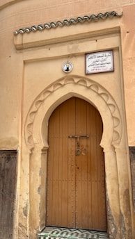 a large wooden door with a sign above it