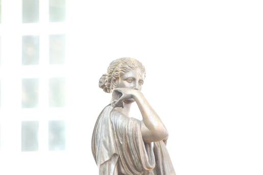 a statue of a woman holding her hand to her face