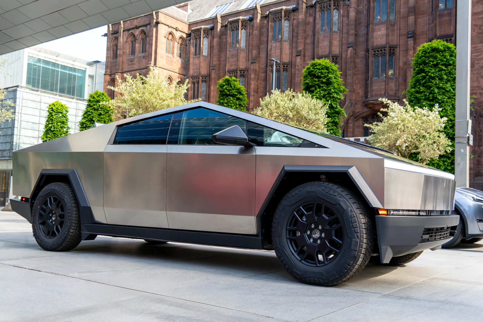 A stainless Tesla Cybertruck parked on a city street