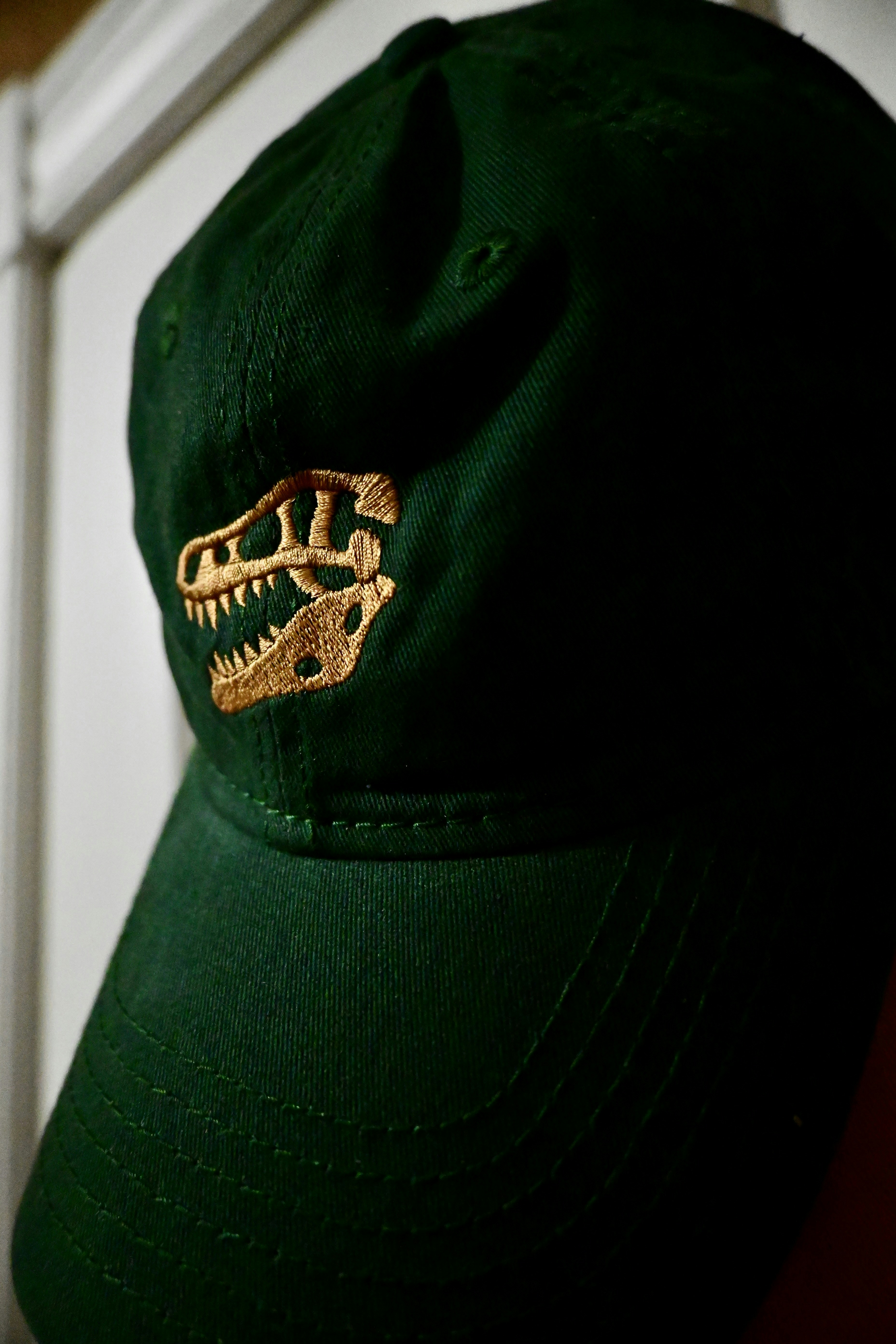 Structured baseball cap in dark green with gold Bayou Golf embroidery, worn-in streetwear look