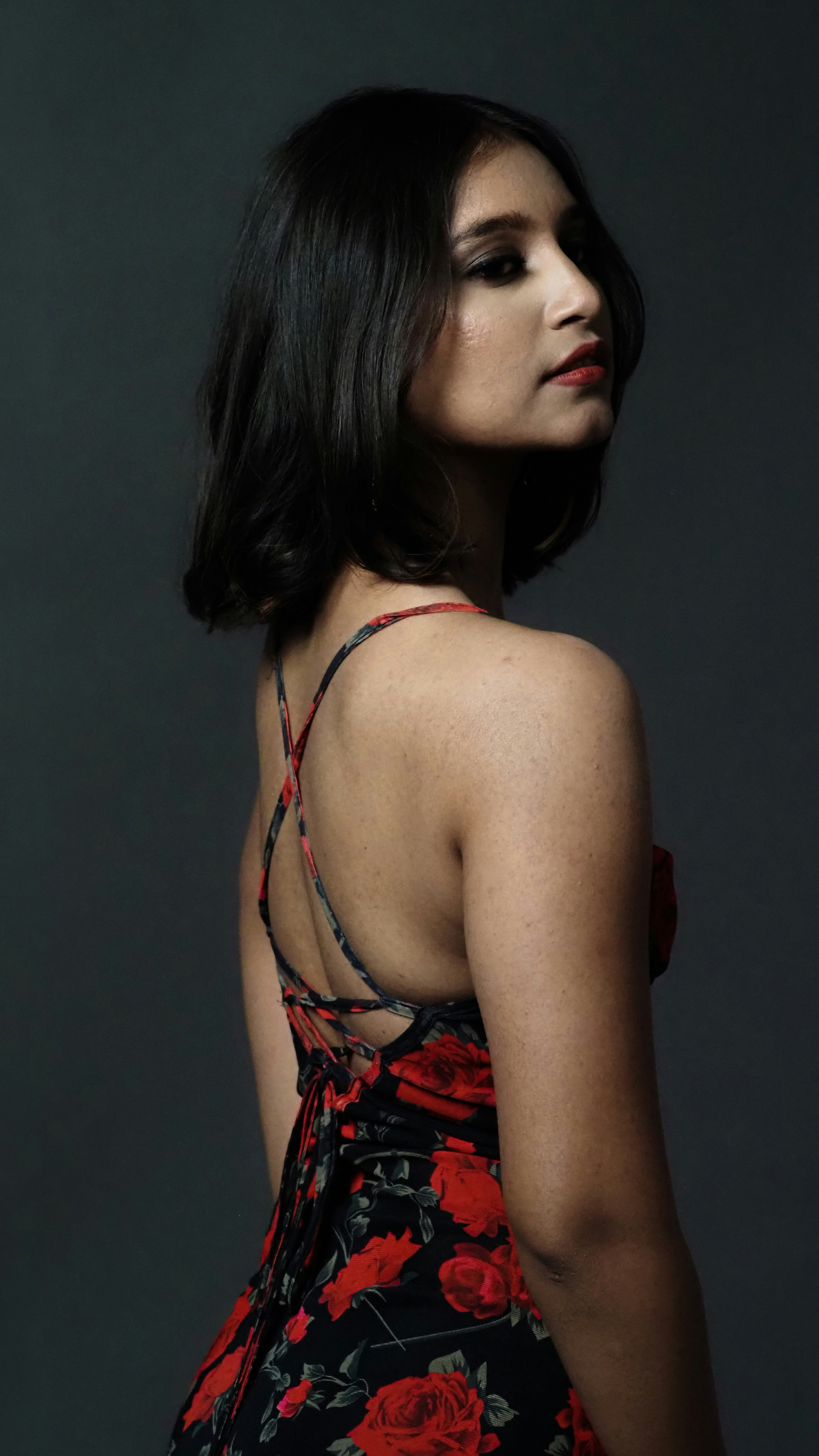 a woman in a red and black floral dress