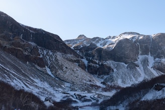 a snow covered mountain with a valley below