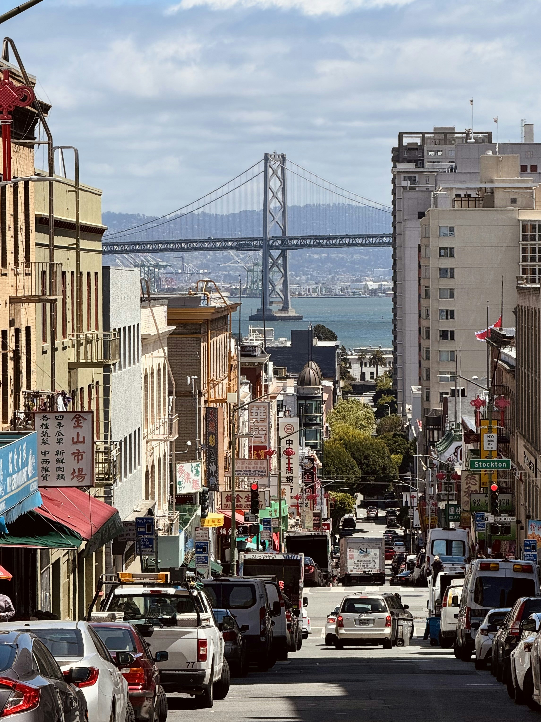 a city street filled with lots of traffic next to a bridge