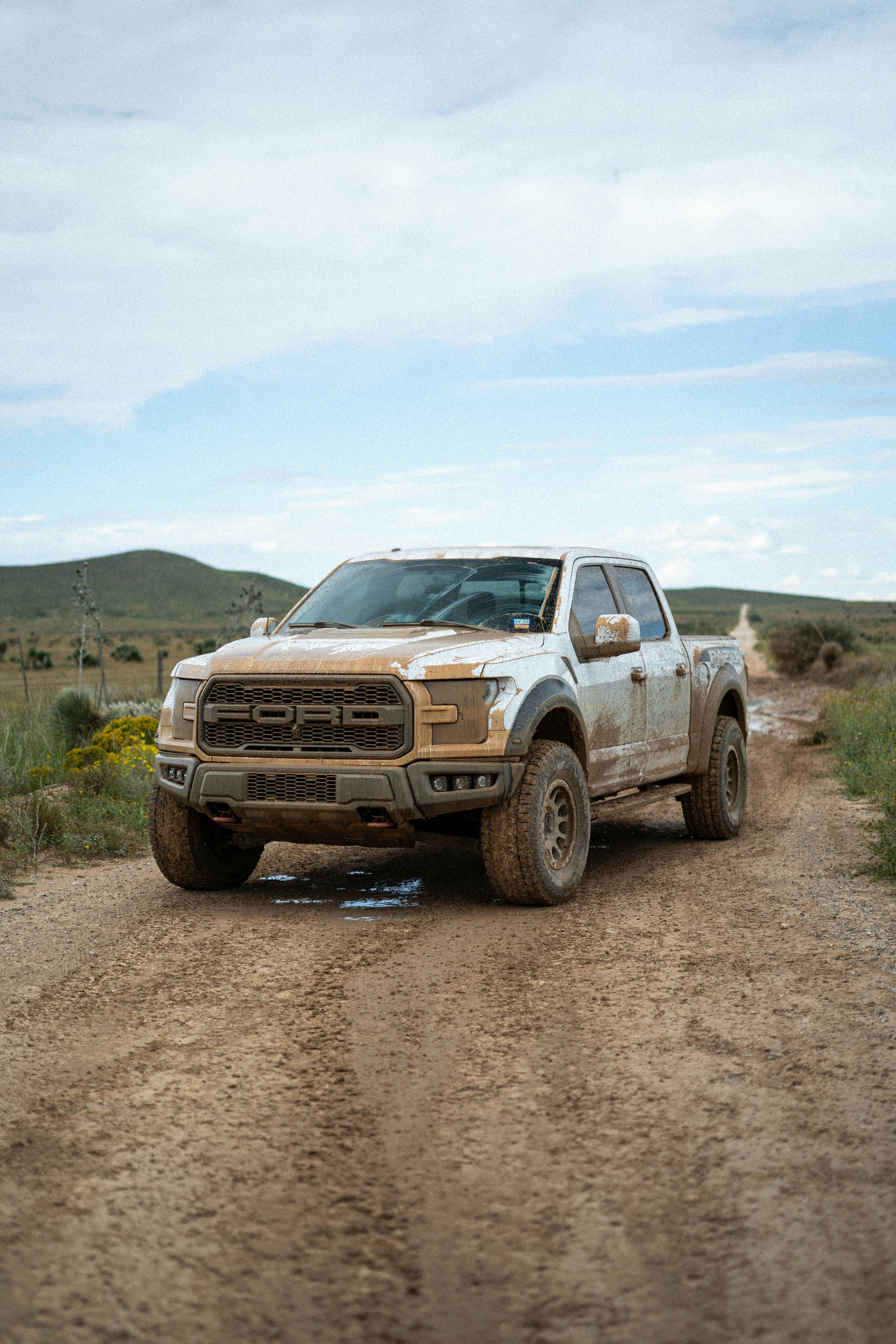 un camion blanc roulant sur un chemin de terre