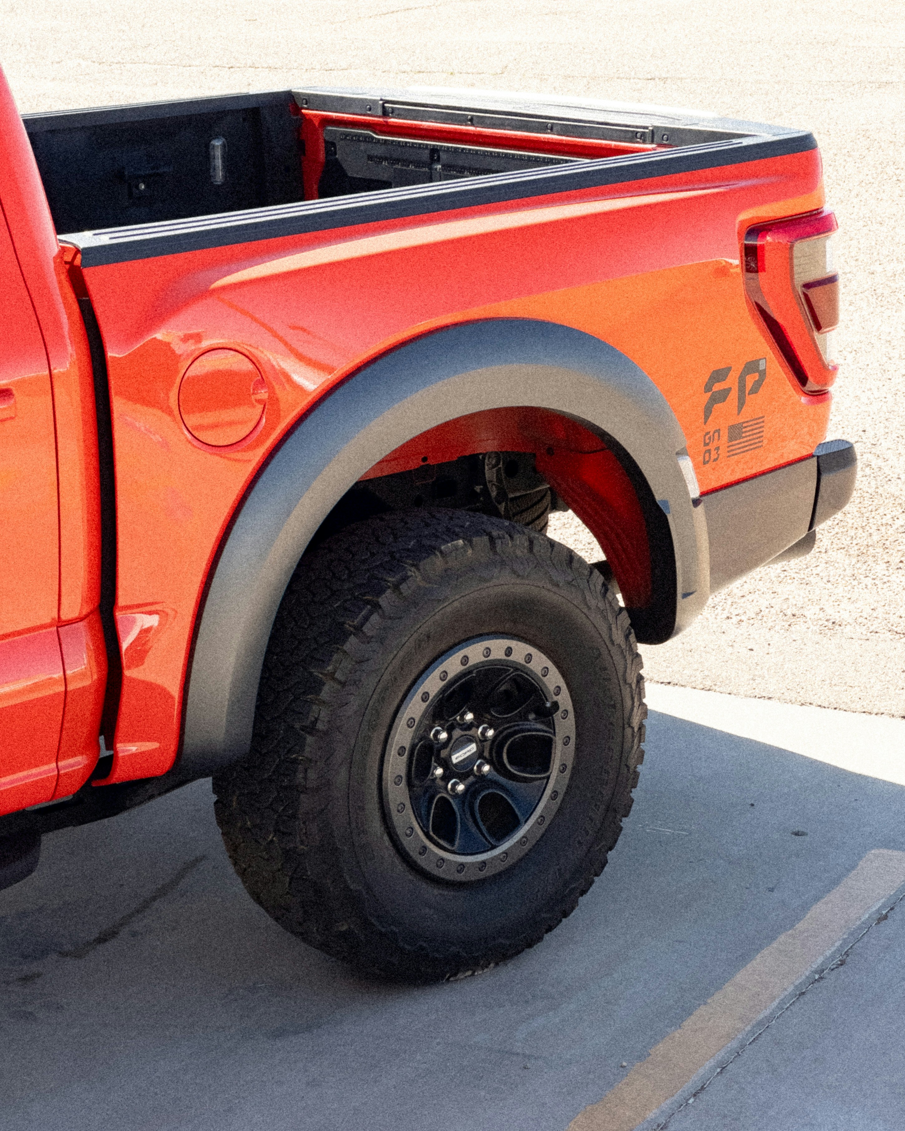 un camion orange vif garé dans un parking