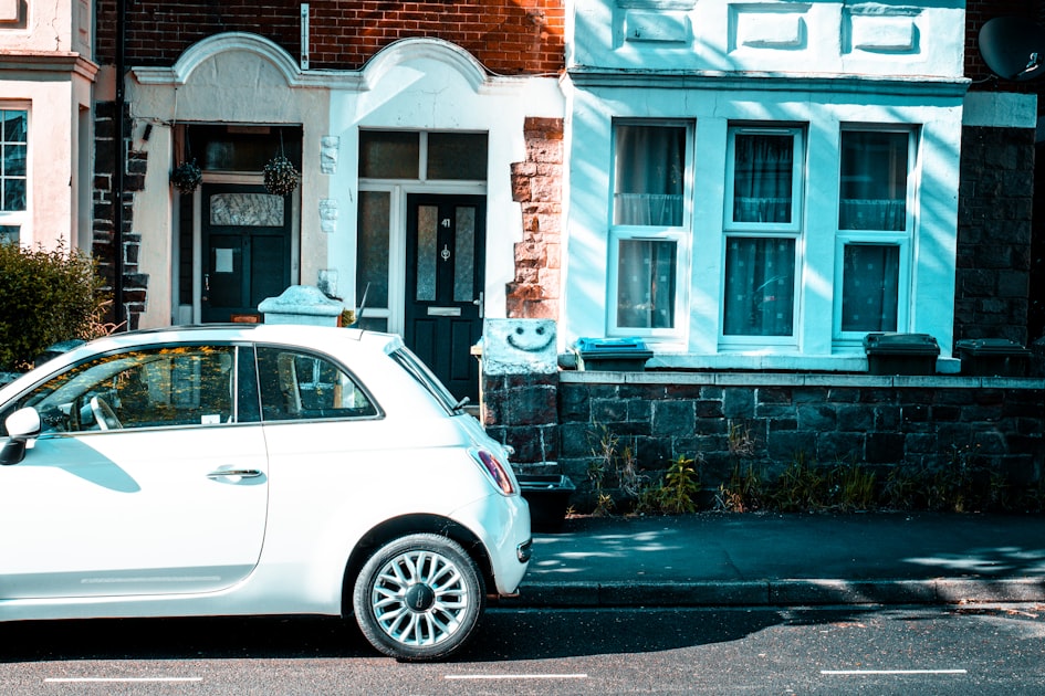 a small white car parked on the side of the road