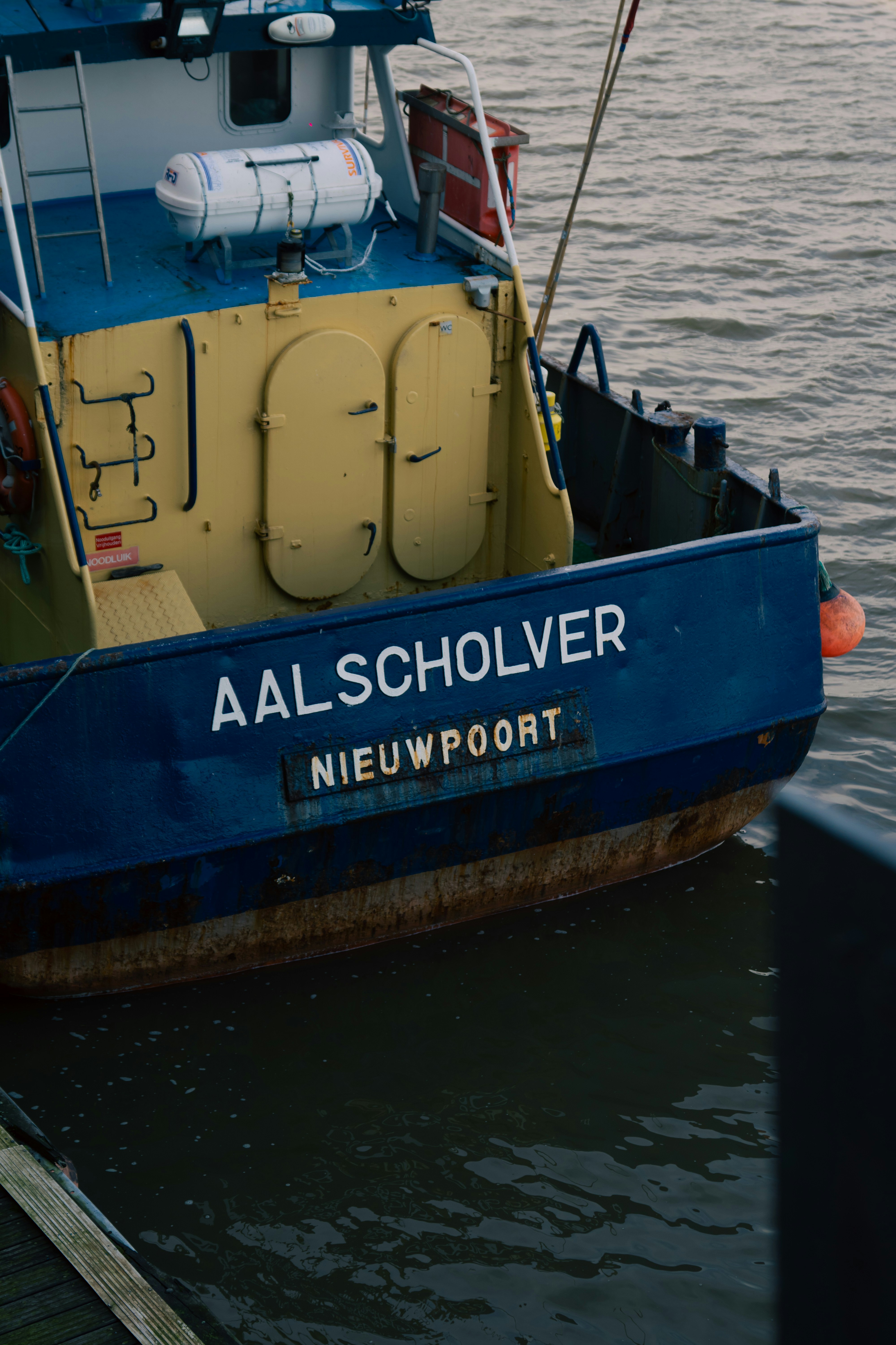 a yellow and blue boat sitting in the water