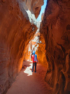 a couple of people that are walking through some rocks