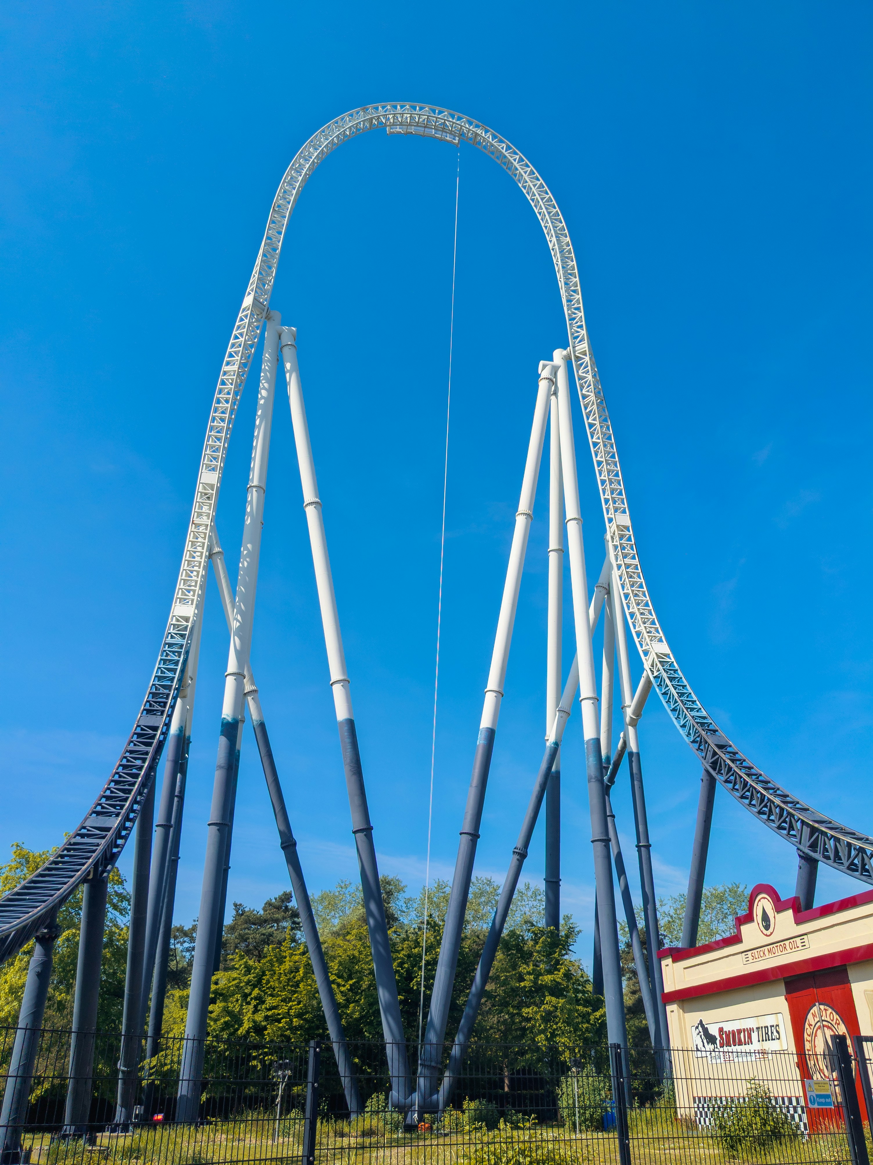 a roller coaster going through a park on a sunny day