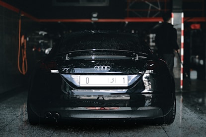 an audi car parked in a garage with a man standing next to it